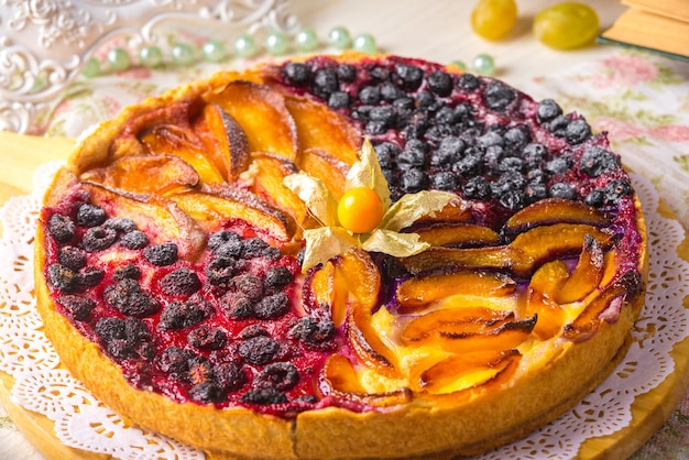 Berry pie, a tart filled with jam made from black currants, in glass form a gray background. Selective focus, close-up.