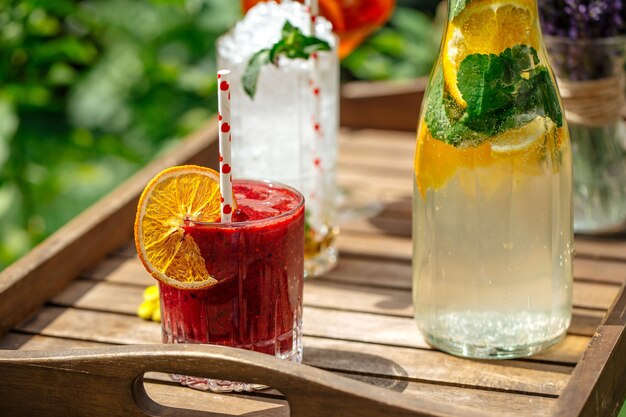 Berry smoothie with lemonade and cocktails on the wooden tray