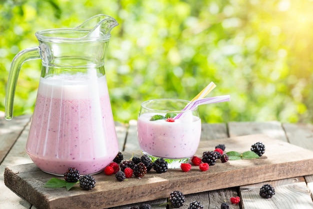 Berry smoothie or yogurt in jug and glass