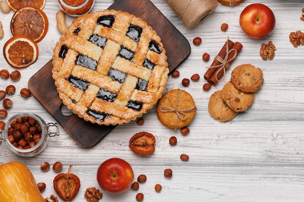 Berry tart pie on wooden board on white wooden table