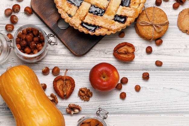 Berry tart pie on wooden board on white wooden table