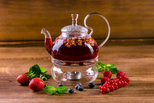 Photo berry tea in a glass teapot