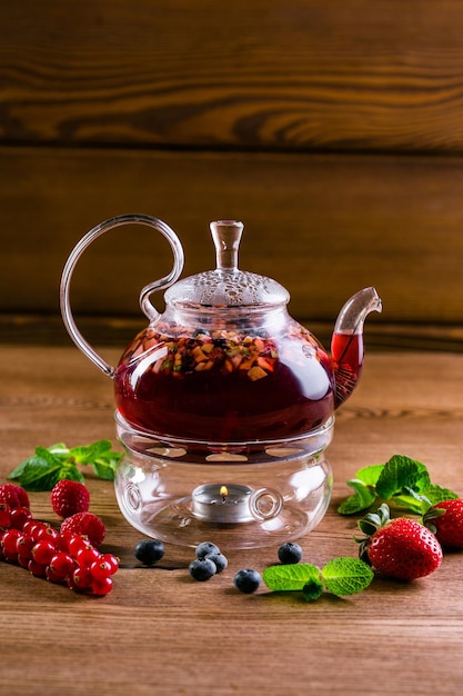 Photo berry tea in a glass teapot