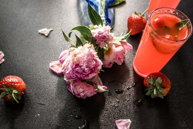 Foto un mojito alla fragola con un tocco tropicale su un cocktail classico fragole fresche, lime e foglie di menta si combinano per creare una bevanda vivace e aromatica servito su ghiaccio in bicchiere su uno sfondo scuro