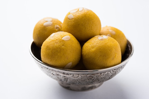 Besan Laddoo - Geroosterd grammeel gemengd met Desi Ghee en suiker om smakelijke en ronde zoete Laddu te maken. Geserveerd in een kom. selectieve focus