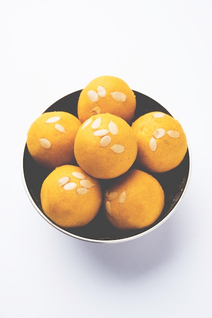 Besan Laddoo - 구운 그램 가루에 Desi Ghee 및 설탕을 섞어서 맛있고 둥근 모양의 달콤한 Laddu를 만듭니다. 그릇에 제공됩니다. 선택적 초점