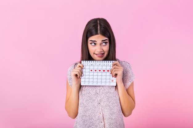 Beschaamd schattig meisje met menstruele kalender