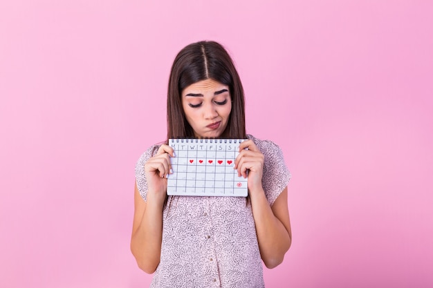 Beschaamd schattig meisje met menstruele kalender