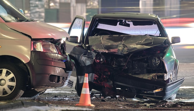 Beschadigd in voertuigen met zware auto-ongelukken na botsing op de plaats van de crash in de stad 's nachts Verkeersveiligheid en verzekeringsconcept