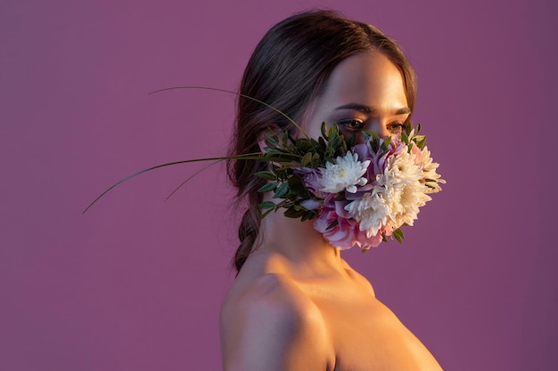 Beschermend gezichtsmasker in bloemen en bloembladen voor het ontwaken van de natuur tijdens de quarantaineperiode...