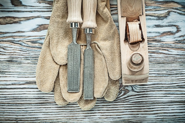 Beschermende handschoenen platte beitels schaafmachine op houten bord.