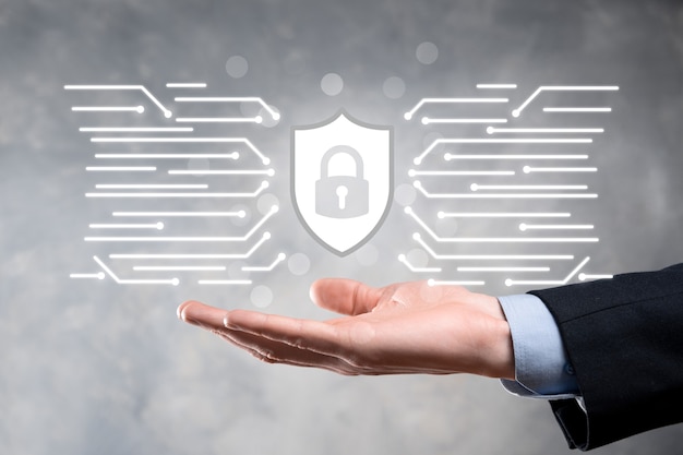 Bescherming netwerkbeveiligingscomputer en veilig uw gegevensconcept, zakenman houden schild beschermen pictogram. slotsymbool, concept over veiligheid, cyberveiligheid en bescherming tegen gevaren.