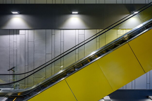 Beside yellow escalator with lamps