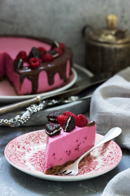 Besmousse cake versierd met stukjes oreo koekjes en frambozen.