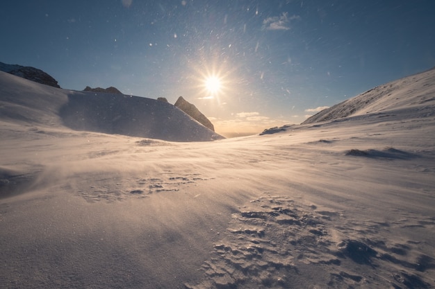 Besneeuwde berg in blizzard op piek bij zonsondergang