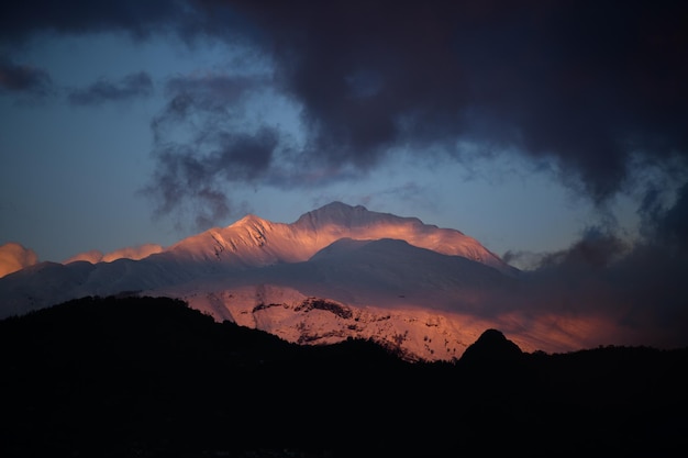 Besneeuwde berg verlicht door een roze zonsondergangkleur