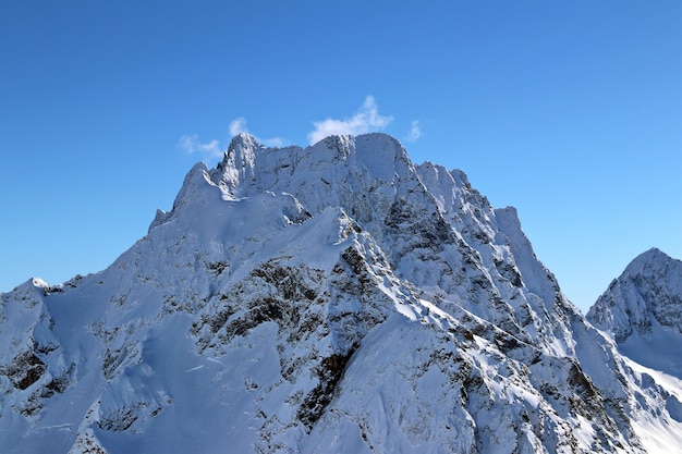 Besneeuwde bergen toppen in de wolken blauwe lucht Kaukasus