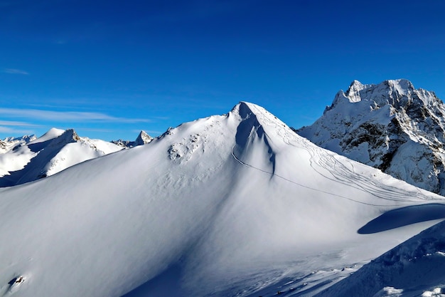 Besneeuwde bergen toppen in de wolken blauwe lucht Kaukasus