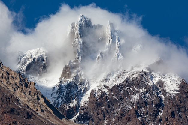 Besneeuwde bergtop in wolken