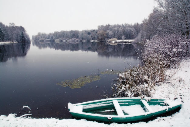 besneeuwde boot bij de vijver