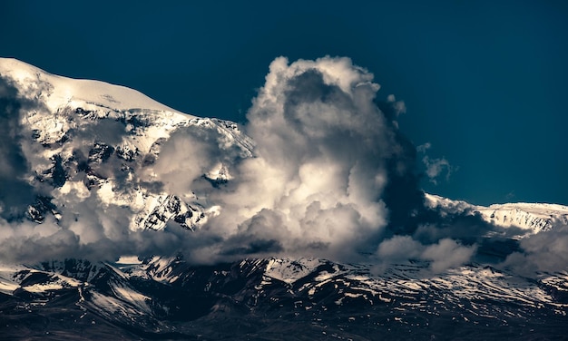 Besneeuwde rotsberg op bewolkte achtergrond