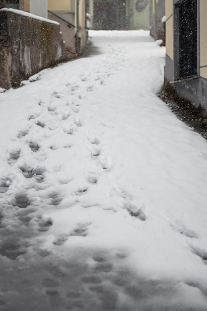 Besneeuwde straat met voetsporen in de sneeuw.