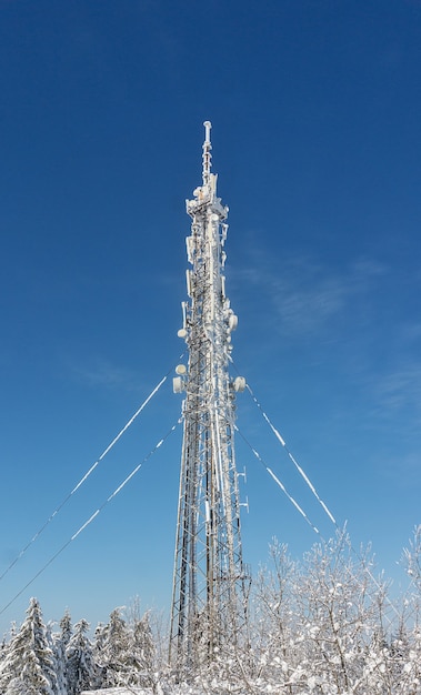 Foto besneeuwde televisietoren tegen de blauwe lucht