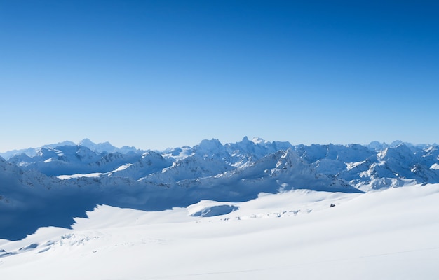 Besneeuwde toppen van kaukasische bergen in de blauwe lucht. elbrus-regio