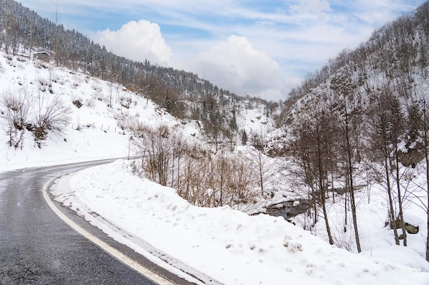 Besneeuwde winterdag kronkelend weglandschap en wolken