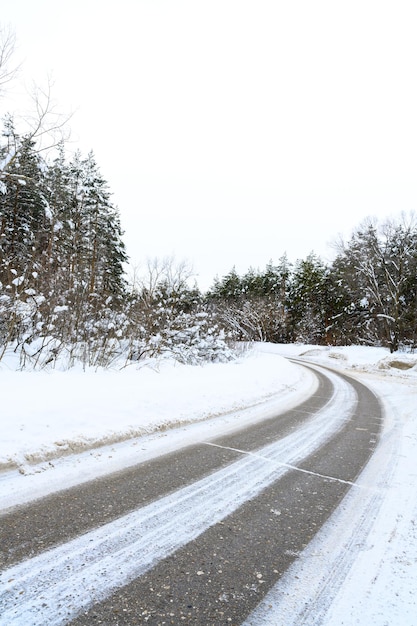 Besneeuwde winterweg in een bergbos