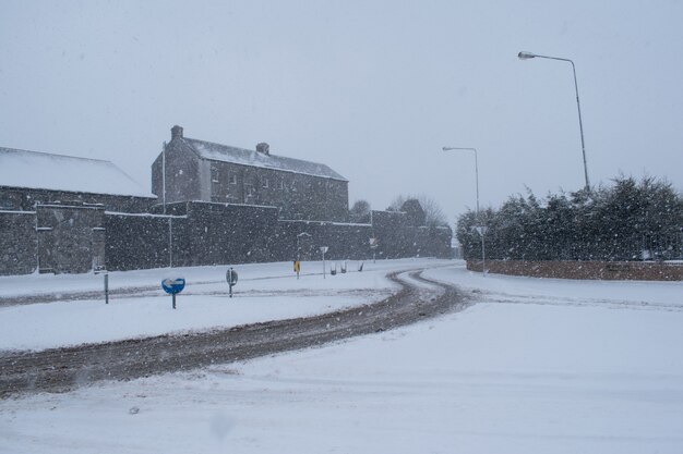 Besneeuwde winterweg tijdens sneeuwstorm. Zware sneeuwstorm.