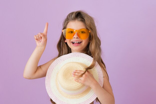 Ребенок в очках показывает на вашу рекламу и сжимает соломенную шляпу.