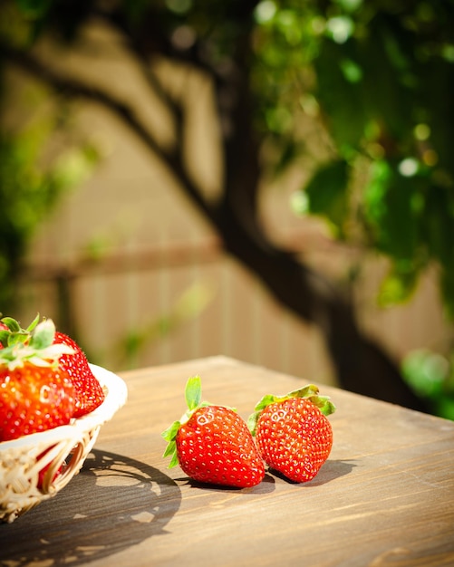 Bessen van sappige aardbeien in een rieten kom in rustieke stijl