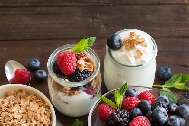 Bessen, vlokken en verse Griekse yoghurt op een houten tafel