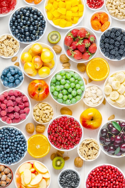 Bessenvruchten en noten op een witte houten achtergrond vegetarisch voedsel