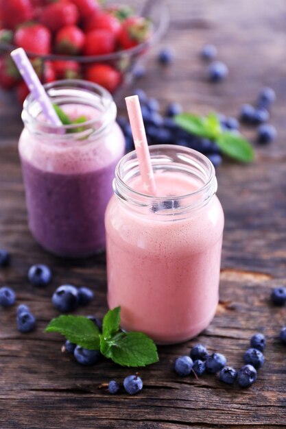 Bessenyoghurt versierd met aardbeien, bosbessen en munt op houten ondergrond