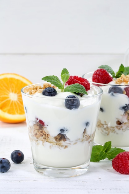 Bessenyoghurt yoghurt met bessen fruit beker muesli staand formaat houten plank copyspace ontbijt