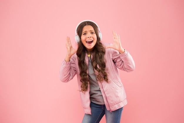 Best fall hits Audio sound Fun and entertainment Music on Happy child enjoy listening to sound track Little girl wear earphones pink background Sound vibrations Music and technology