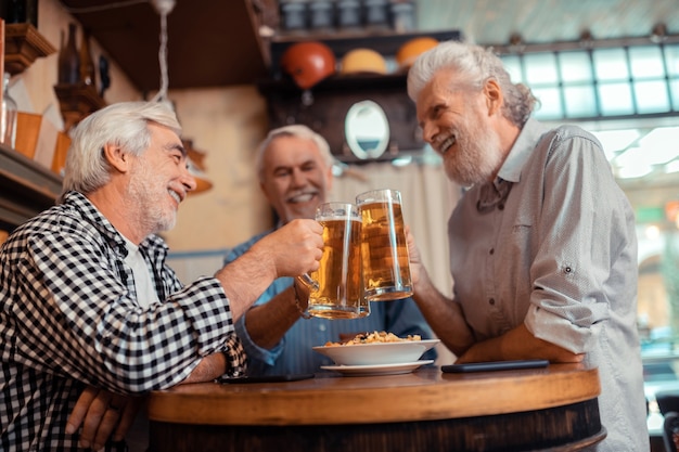 Migliori amici. i migliori amici si sentono allegri mentre bevono birra insieme al pub