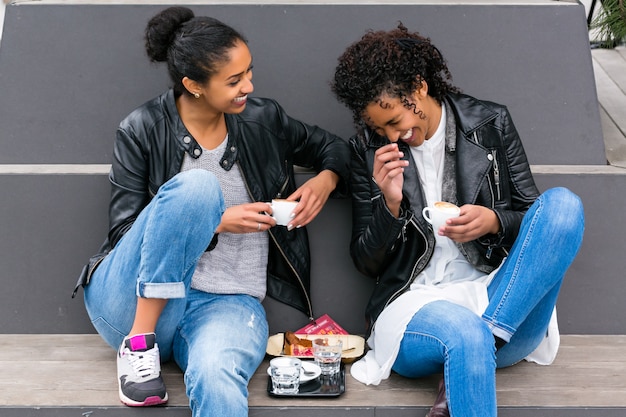 Best friends drinking coffee in city