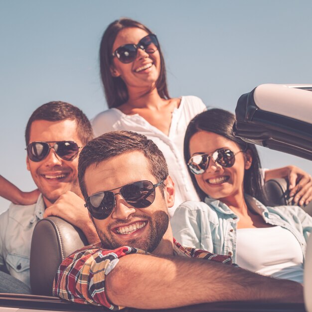 The best friends ever. group of young happy people enjoying\
road trip in their white convertible