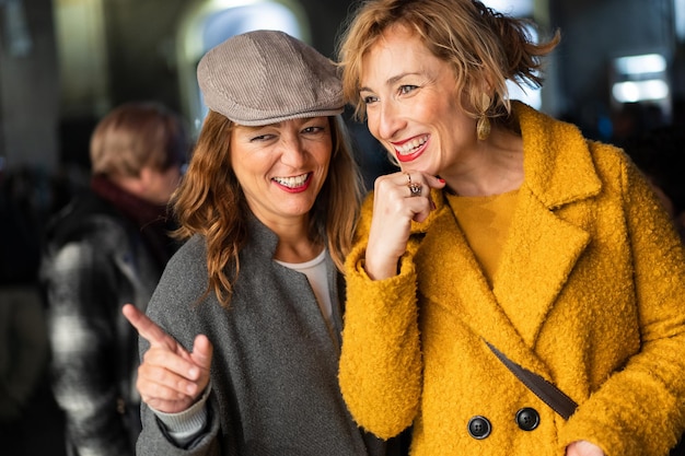 Best friends having fun at the Christmas market Mid aged adult woman wearing coats