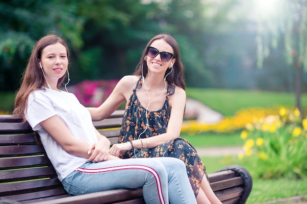 Best friends sitting on a bench in a summer park