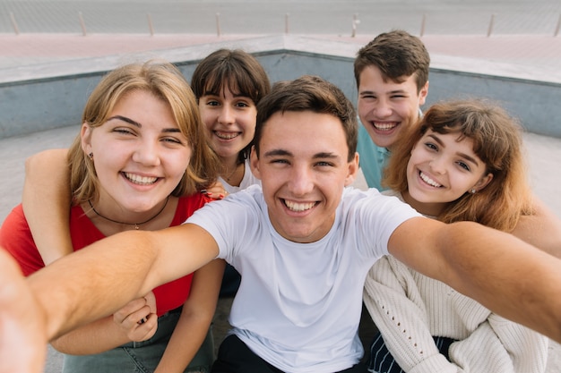 Foto migliori amici prendendo selfie all'aperto con retroilluminazione - concetto di amicizia felice con adolescenti