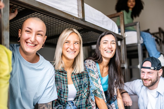 Best friends traveling concept small room in hostel for young people  group of multiracial students spending time together sharing bunk beds having fun