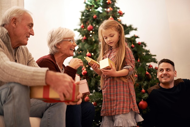 最高の贈り物は一緒にいることですクリスマスに贈り物を交換する多世代家族のショット