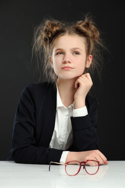 Best goed schoolmeisje zittend aan tafel