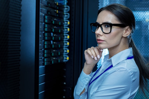 Miglior lavoro. donna seria meditativa che lavora con attrezzature e pensiero