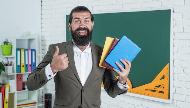 La migliore letteratura torna a scuola educazione formale giorno della conoscenza insegnante barbuto maturo a lezione uomo brutale lavoro in classe con lavagna prepararsi per l'esame docente universitario a lezione