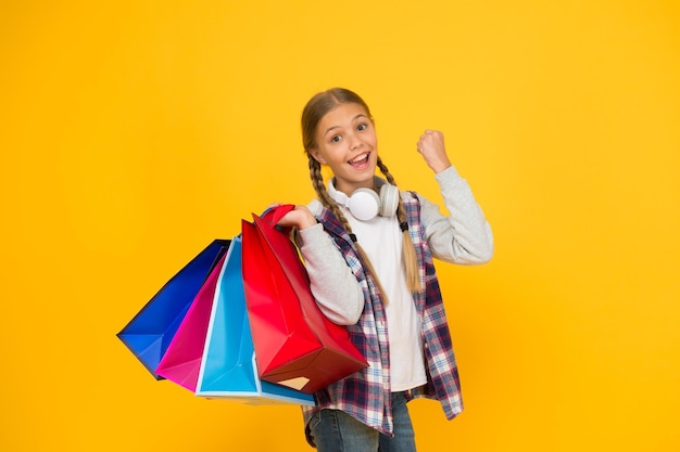 Best outfit ever holiday gifts in packages cyber monday hurry up its total sale Kids fashion Sales and discounts happy small girl after successful shopping adorable child with heavy bags